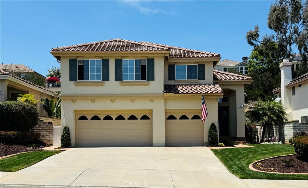 7004 Wildrose Ter, Carlsbad, CA 92011 - mediterranean / spanish-style house with an attached garage, a tiled roof, stucco siding, and concrete driveway