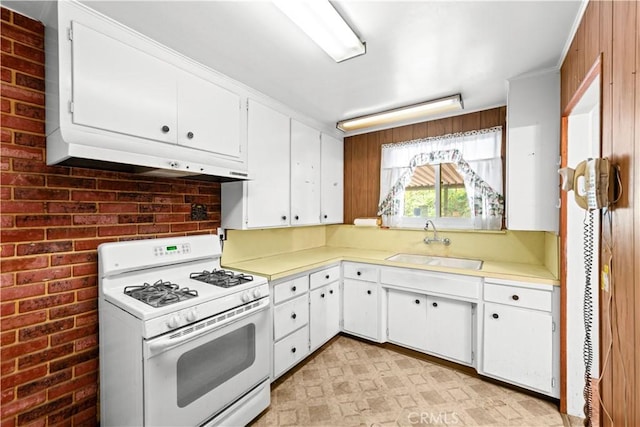 631 N Evergreen St, Burbank, CA 91505 - kitchen featuring gas range gas stove, light countertops, white cabinetry, brick wall, and under cabinet range hood