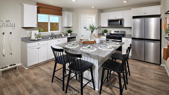30753 Viper Ct, Winchester, CA 92596 - kitchen with appliances with stainless steel finishes, dark wood finished floors, white cabinets, recessed lighting, and light stone counters