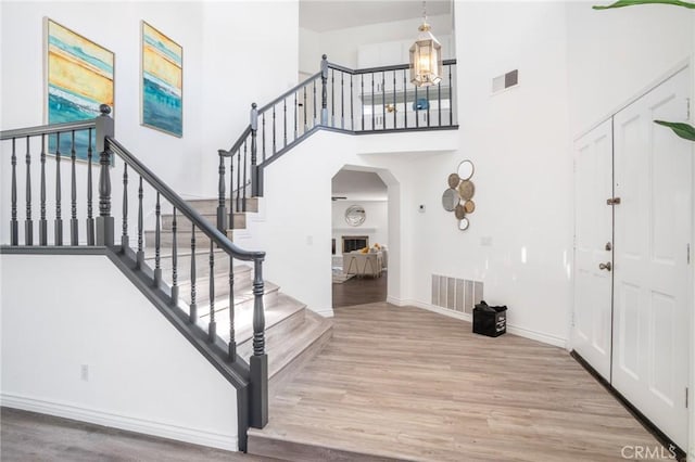 7029 Novara Pl, Rancho Cucamonga, CA 91701 - entrance foyer featuring wood finished floors, a towering ceiling, and arched walkways