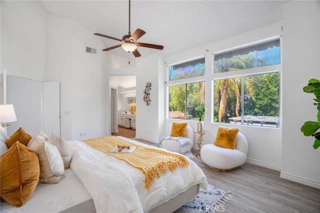 7029 Novara Pl, Rancho Cucamonga, CA 91701 - bedroom with multiple windows, wood finished floors, connected bathroom, and high vaulted ceiling
