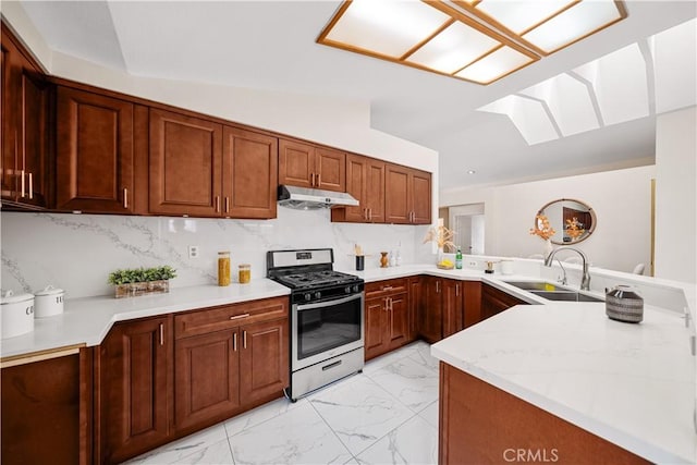 2988 Dartmouth Cir, Corona, CA 92879 - kitchen featuring gas stove, under cabinet range hood, light marble finish floors, a skylight, and a peninsula