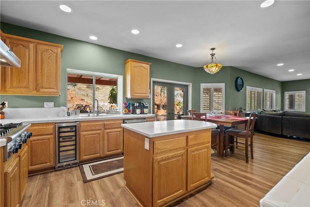 15355 Michael Crest Dr, Canyon Country, CA 91387 - kitchen with beverage cooler, stainless steel gas stovetop, light wood-style flooring, light countertops, and a center island