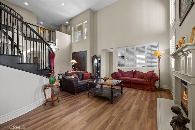 15355 Michael Crest Dr, Canyon Country, CA 91387 - living area featuring wood finished floors, stairway, a towering ceiling, a glass covered fireplace, and recessed lighting