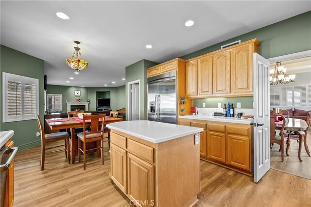 15355 Michael Crest Dr, Canyon Country, CA 91387 - kitchen with stainless steel built in fridge, light wood finished floors, light brown cabinetry, a chandelier, and a center island