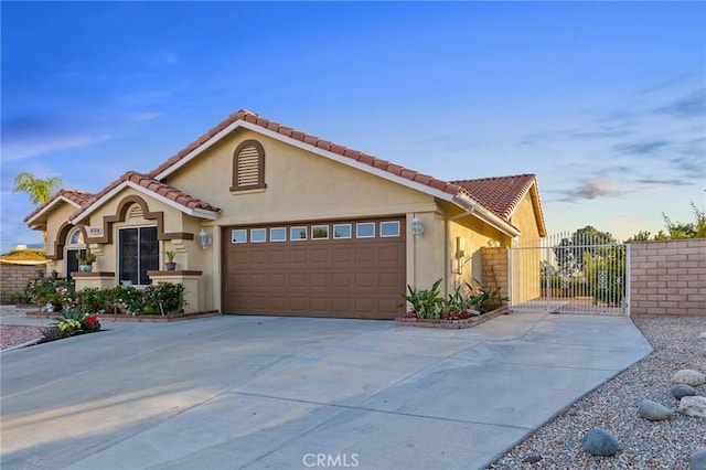 2157 Pecan Tree St, Hemet, CA 92545 - mediterranean / spanish-style home with driveway, a garage, stucco siding, a gate, and a tiled roof