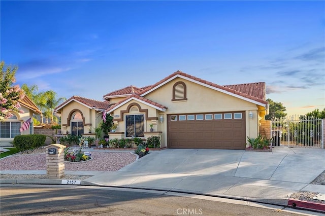 2157 Pecan Tree St, Hemet, CA 92545 - mediterranean / spanish-style house with stucco siding, concrete driveway, a garage, and a tiled roof