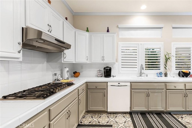 2157 Pecan Tree St, Hemet, CA 92545 - kitchen with white dishwasher, under cabinet range hood, stainless steel gas cooktop, tile countertops, and crown molding
