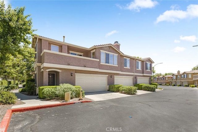 39635 Columbia Union Dr Unit C, Murrieta, CA 92563 - townhome / multi-family property with a chimney, stucco siding, and a garage