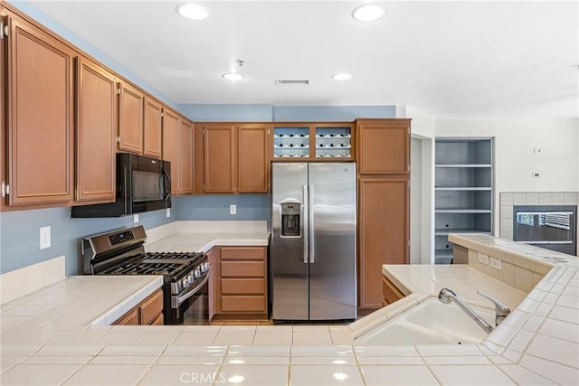 39635 Columbia Union Dr Unit C, Murrieta, CA 92563 - kitchen featuring stainless steel appliances, tile counters, recessed lighting, and a tile fireplace