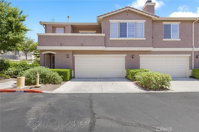 39635 Columbia Union Dr Unit C, Murrieta, CA 92563 - view of property with stucco siding, a chimney, concrete driveway, and a garage