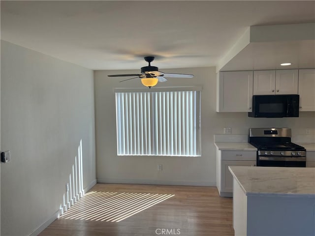 552 Canyon Dr Unit 38, Oceanside, CA 92054 - kitchen with black microwave, stainless steel range oven, white cabinetry, light wood-style flooring, and a ceiling fan