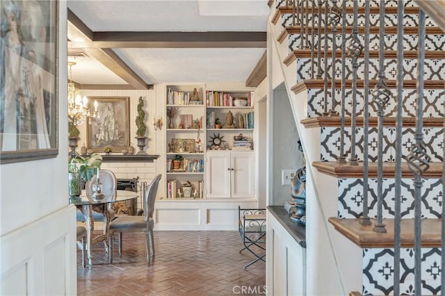 24042 Ingomar St, West Hills, CA 91304 - staircase featuring beam ceiling, a decorative wall, brick floors, and a chandelier