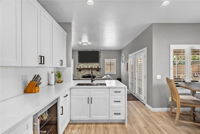 37152 57th St E, Palmdale, CA 93552 - kitchen featuring wine cooler, a stone fireplace, light countertops, light wood finished floors, and recessed lighting