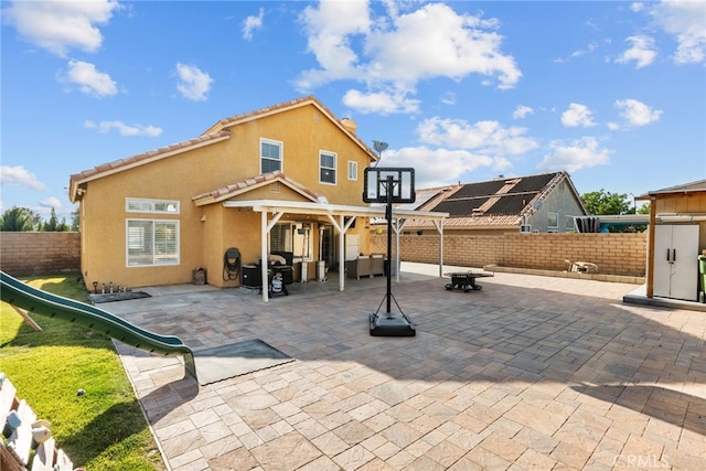 37152 57th St E, Palmdale, CA 93552 - rear view of house featuring stucco siding, a fenced backyard, a patio area, a pergola, and a playground