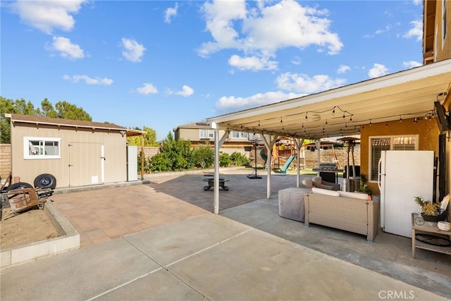 37152 57th St E, Palmdale, CA 93552 - fenced backyard featuring a playground, a patio, grilling area, and a storage shed