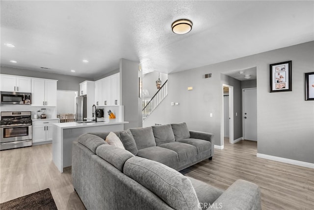 37152 57th St E, Palmdale, CA 93552 - living area featuring light wood-style flooring, stairway, and recessed lighting