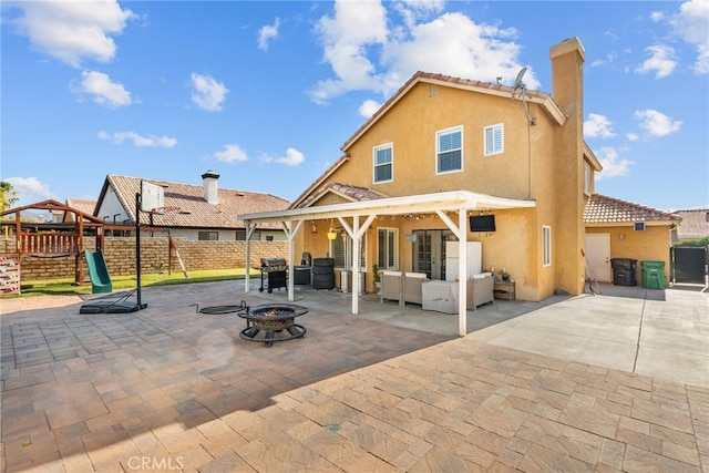 37152 57th St E, Palmdale, CA 93552 - back of house with an outdoor living space with a fire pit, stucco siding, a fenced backyard, a patio area, and a chimney