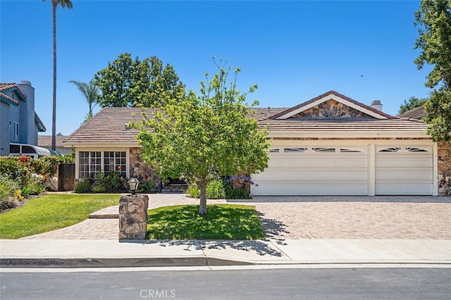 3386 Montagne Way, Thousand Oaks, CA 91362 - view of front of house featuring stone siding, a tile roof, driveway, an attached garage, and a front lawn
