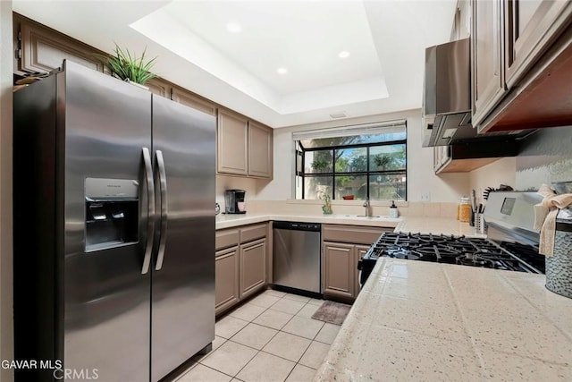 425 W W Ave J5, Unit 36, Lancaster, CA 93534 - kitchen featuring stainless steel appliances, light tile patterned floors, a tray ceiling, ventilation hood, and recessed lighting