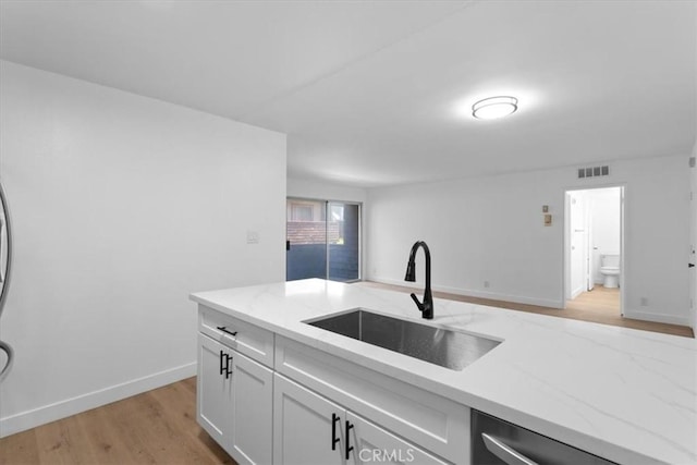5403 Newcastle Ave Unit 19, Encino, CA 91316 - kitchen featuring stainless steel dishwasher, light wood-style floors, white cabinetry, and light stone counters