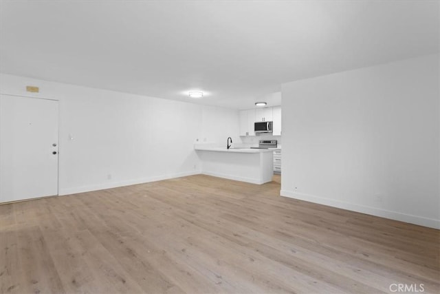 5403 Newcastle Ave Unit 19, Encino, CA 91316 - unfurnished living room with light wood-style floors and baseboards