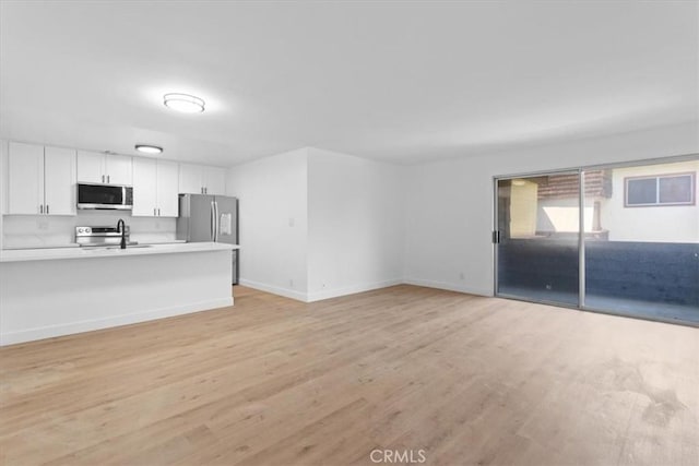 5403 Newcastle Ave Unit 19, Encino, CA 91316 - unfurnished living room featuring light wood-style flooring and baseboards