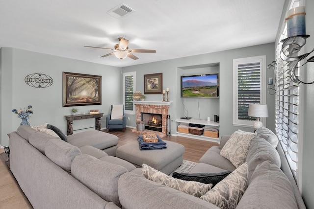 42207 Kimberly Way, Murrieta, CA 92562 - living area featuring a fireplace, a ceiling fan, and light wood finished floors