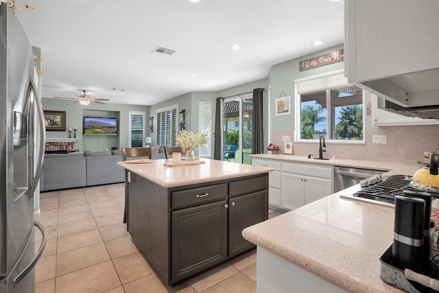 42207 Kimberly Way, Murrieta, CA 92562 - kitchen featuring appliances with stainless steel finishes, ceiling fan, light tile patterned floors, open floor plan, and a center island