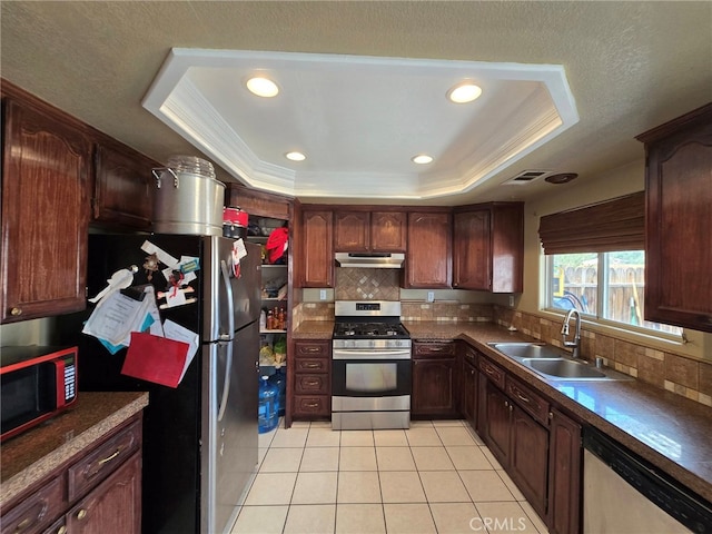9294 Manteca Ave, Hesperia, CA 92345 - kitchen featuring appliances with stainless steel finishes, under cabinet range hood, a tray ceiling, light tile patterned floors, and ornamental molding