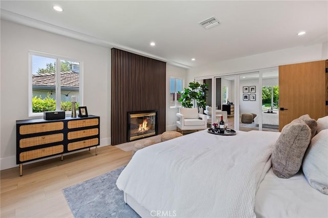439 S Lamer St, Burbank, CA 91506 - bedroom featuring light wood-style flooring, recessed lighting, multiple windows, a fireplace, and access to exterior