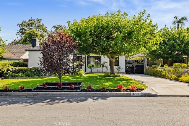 439 S Lamer St, Burbank, CA 91506 - obstructed view of property with a front yard, stucco siding, a chimney, concrete driveway, and a carport
