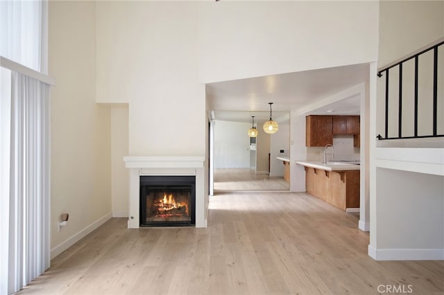 3350 M St Unit 33, Merced, CA 95348 - unfurnished living room featuring a glass covered fireplace, light wood finished floors, and a towering ceiling