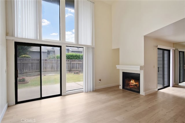 3350 M St Unit 33, Merced, CA 95348 - unfurnished living room with a high ceiling, a glass covered fireplace, and wood finished floors