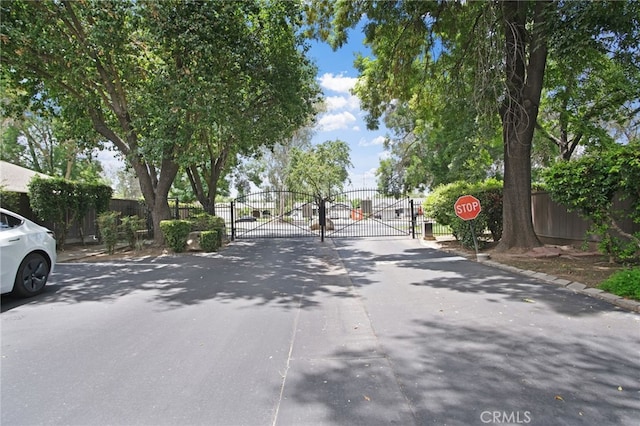 3350 M St Unit 33, Merced, CA 95348 - view of asphalt street with a gate, traffic signs, a gated entry, and curbs