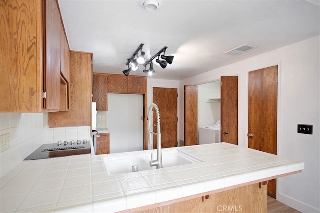 3350 M St Unit 33, Merced, CA 95348 - kitchen with tile countertops, brown cabinetry, backsplash, and a peninsula