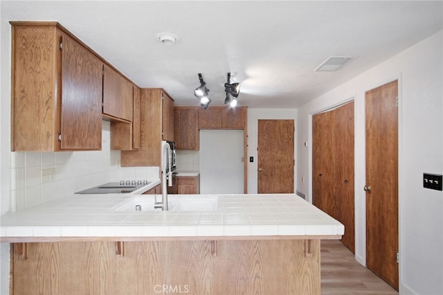 3350 M St Unit 33, Merced, CA 95348 - kitchen with a peninsula, tile counters, backsplash, and light wood finished floors