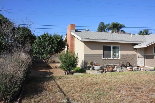 6400 Tournament Dr, Jurupa Valley, CA 92509 - view of property exterior with stucco siding, a chimney, and a shingled roof
