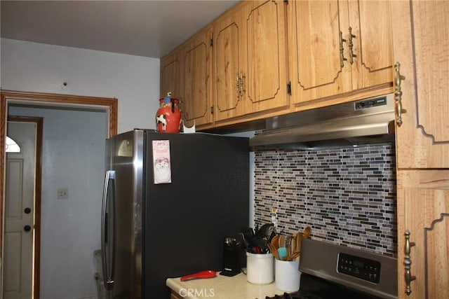 6400 Tournament Dr, Jurupa Valley, CA 92509 - kitchen with freestanding refrigerator, under cabinet range hood, backsplash, range, and light countertops