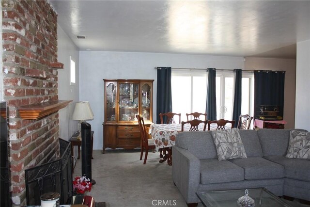 6400 Tournament Dr, Jurupa Valley, CA 92509 - carpeted living area featuring healthy amount of natural light and a brick fireplace
