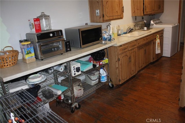 6400 Tournament Dr, Jurupa Valley, CA 92509 - kitchen featuring stainless steel microwave, dark wood finished floors, brown cabinets, light countertops, and washing machine and dryer