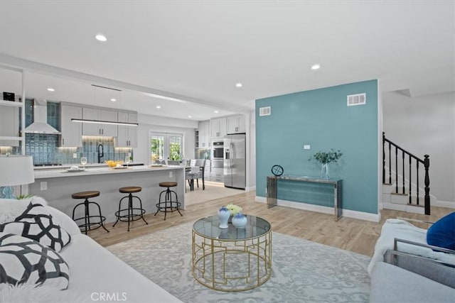 16842 Liggett St, Los Angeles, CA 91343 - living area featuring stairs, light wood-style flooring, and recessed lighting