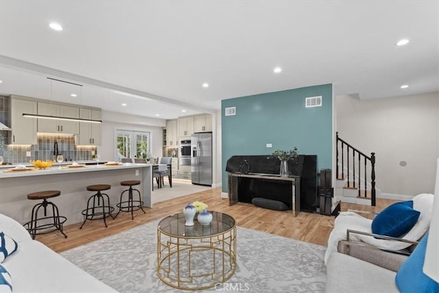 16842 Liggett St, Los Angeles, CA 91343 - living room featuring stairway, recessed lighting, light wood-style flooring, and french doors
