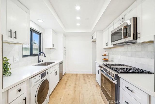 33871 Copper Lantern St, Dana Point, CA 92629 - kitchen with washer / clothes dryer, stainless steel appliances, recessed lighting, light wood-type flooring, and white cabinets