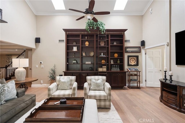 9911 Overhill Dr, North Tustin, CA 92705 - living room featuring light wood finished floors, ceiling fan, a skylight, and ornamental molding