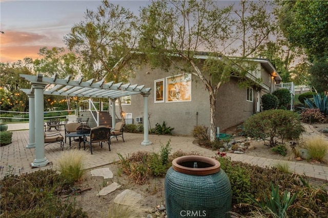 9911 Overhill Dr, North Tustin, CA 92705 - back of property at dusk featuring a pergola, stucco siding, and a patio area