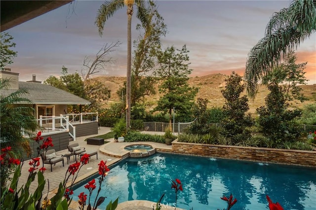 9911 Overhill Dr, North Tustin, CA 92705 - pool at dusk featuring a deck with mountain view, a pool with connected hot tub, and a patio area
