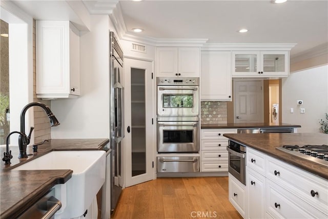 9911 Overhill Dr, North Tustin, CA 92705 - kitchen featuring a warming drawer, stainless steel appliances, dark countertops, white cabinets, and backsplash