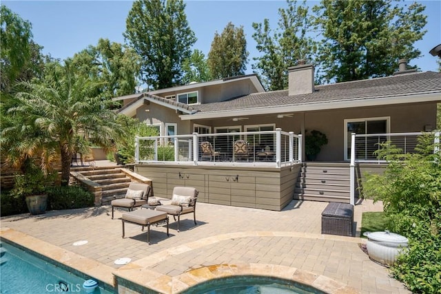 9911 Overhill Dr, North Tustin, CA 92705 - back of property with stucco siding, stairs, a chimney, and an outdoor hot tub