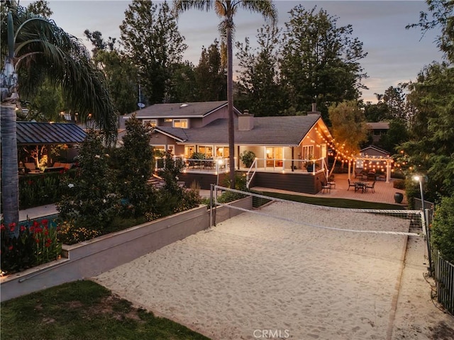 9911 Overhill Dr, North Tustin, CA 92705 - back of property at dusk with volleyball court, a tiled roof, and stucco siding